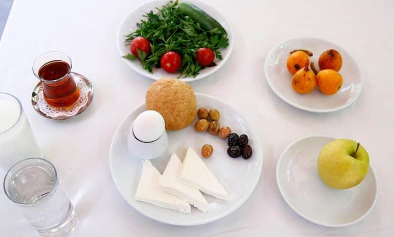 çay, süt, yumurta, peynir, domates, elma, zeytin olan kahvaltılıklar