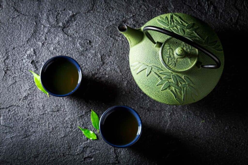 yeşil renkli çay demliği ve 2 fincan