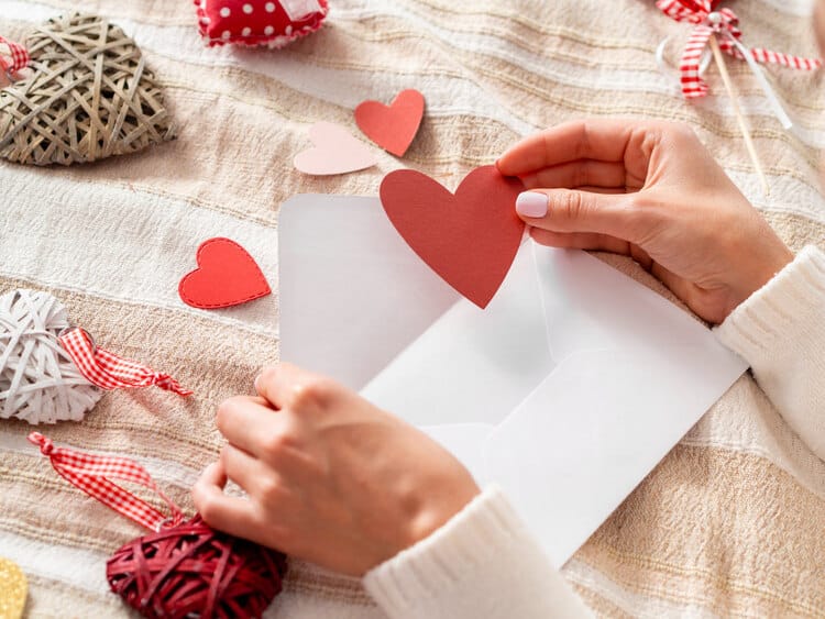 hand putting heart envelope